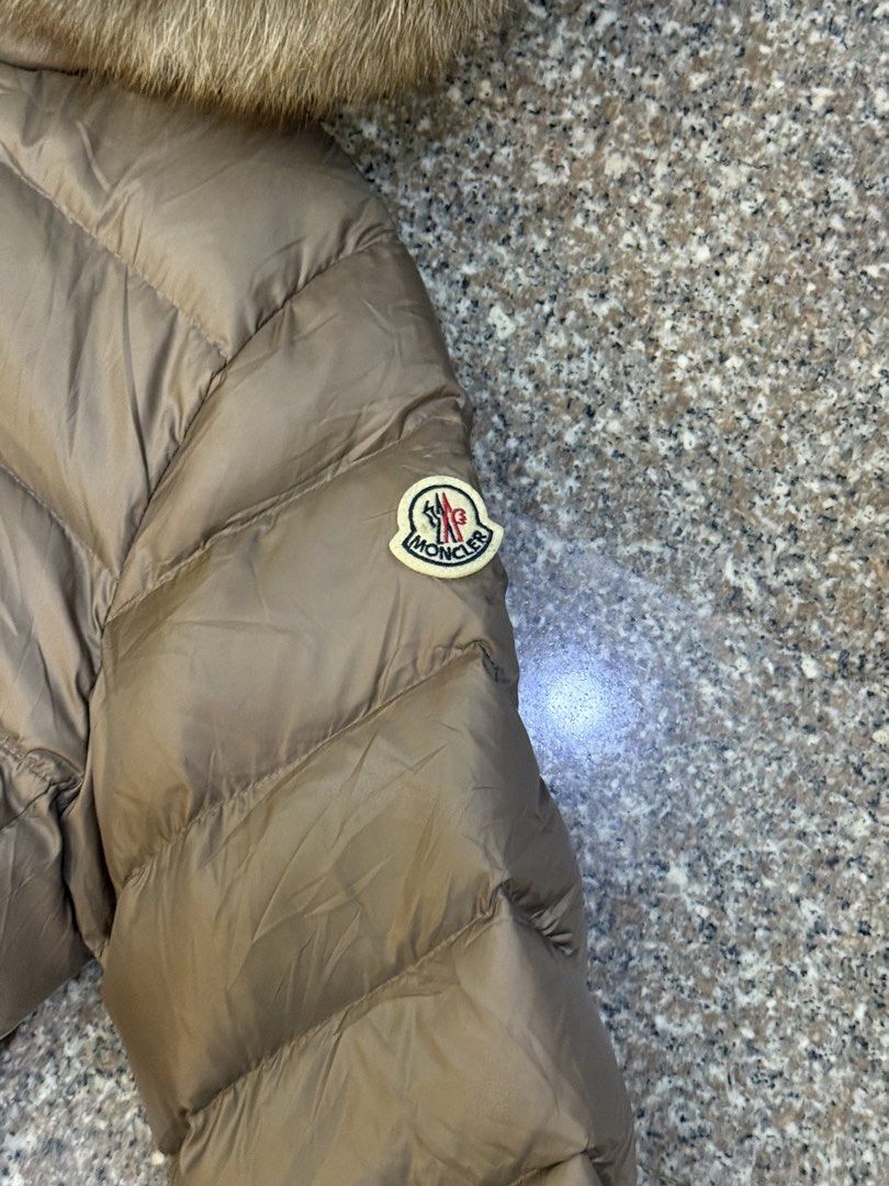 Moncler Down Jacket with Fur Hood Size 4 (Category: Coats, Jackets and Outerwear) located in Manila. Submitted by declutterpromax (Listing ID 1463848372, Image 2). Description: - Moncler puffer jacket - Taupe color - Size 4 - Luxurious fur-trimmed hood - Iconic Moncler logo on sleeve - DIST certified down for superior warmth - Perfect for cold weather.