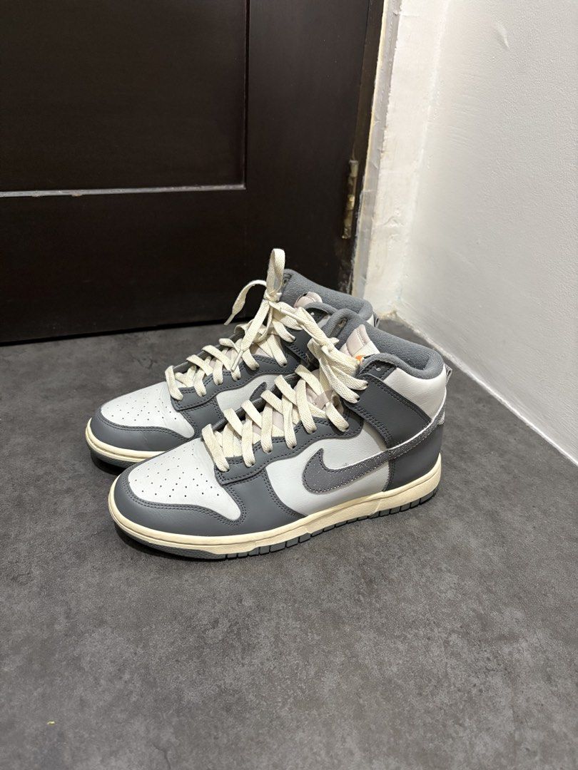 Nike Dunk High Grey White (Category: Sneakers) located in Taguig. Submitted by ernatrambulo10 (Listing ID 1463890414, Image 1). Description: - Classic Nike Dunk Highs - Grey and white colorway - Clean, high-top design - Cream-colored laces for contrast - Durable rubber sole for grip - Versatile for casual styling.
