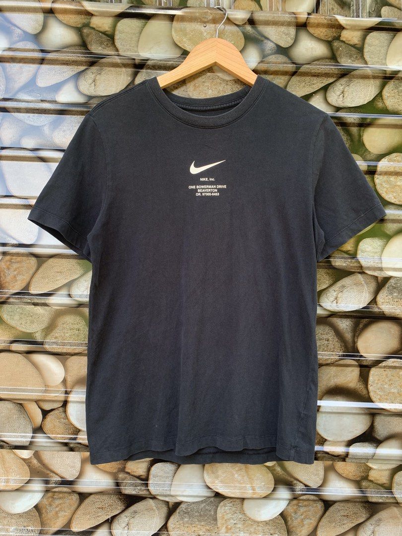 Nike "Swoosh By Nike" Tee - Black (Category: Tshirts & Polo Shirts ) located in Aloran. Submitted by chester78864 (Listing ID 1463903006, Image 2). Description: - Black Nike T-shirt, Size M - Features 'Swoosh By Nike' graphic and Nike Inc. address on the back - Small Nike logo and address on the front - Made of 100% cotton - Ideal for casual everyday wear.