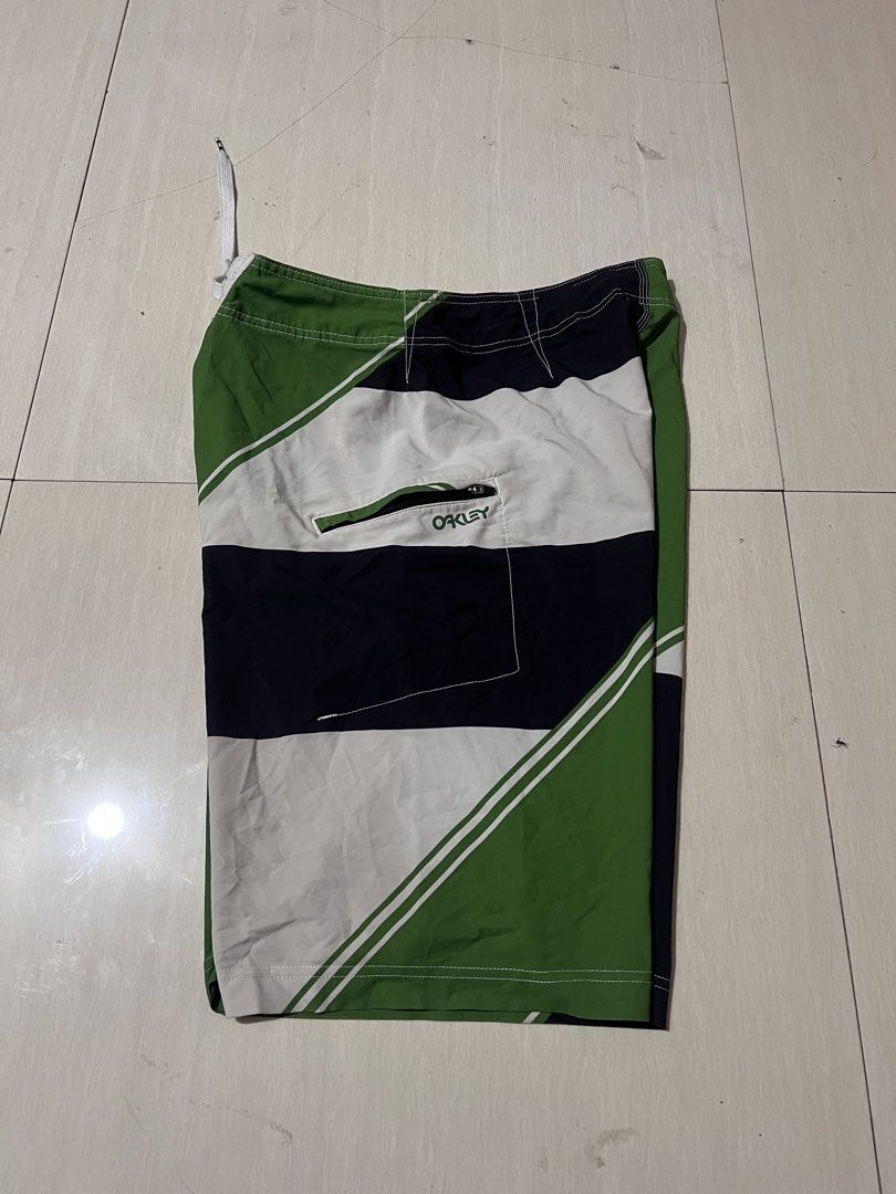 Oakley Board Shorts Green Black White Geometric Pattern (Category: Swim Trunks & Board Shorts) located in Zamboanga. Submitted by safe.haimer (Listing ID 1463882653, Image 2). Description: - Oakley board shorts -Size 30 -L21.5 - Green, black, and white geometric design - Drawstring waist for adjustable fit - Convenient zippered pocket on the side - Ideal for swimming, surfing, or lounging - Made from a comfortable polyester and spandex blend.