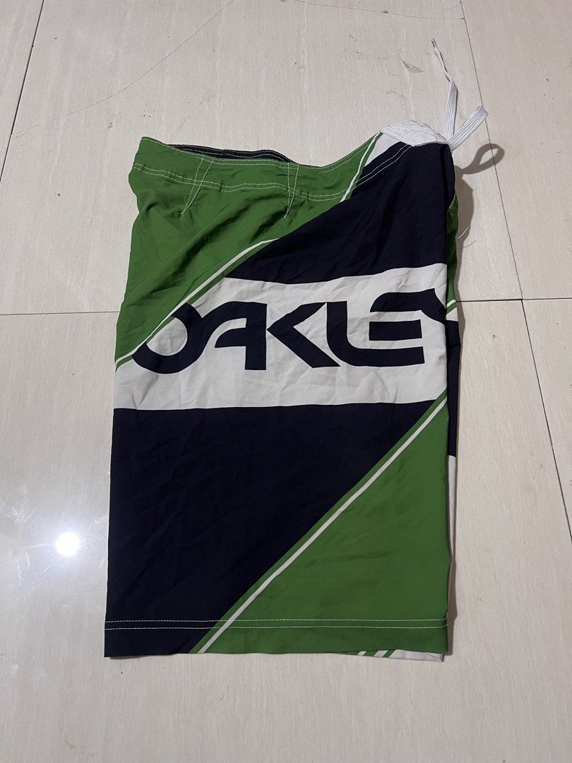 Oakley Board Shorts Green Black White Geometric Pattern (Category: Swim Trunks & Board Shorts) located in Zamboanga. Submitted by safe.haimer (Listing ID 1463882653, Image 3). Description: - Oakley board shorts -Size 30 -L21.5 - Green, black, and white geometric design - Drawstring waist for adjustable fit - Convenient zippered pocket on the side - Ideal for swimming, surfing, or lounging - Made from a comfortable polyester and spandex blend.