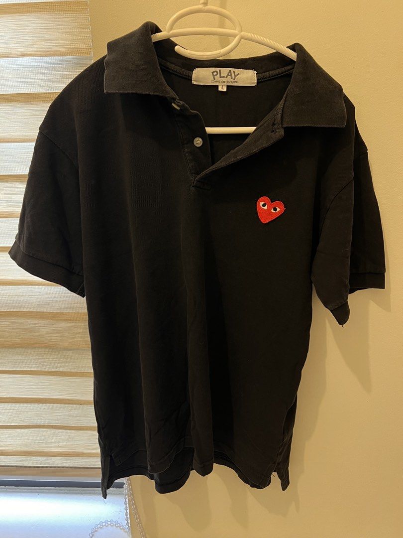 Authentic Comme des Garcons Polo Shirt (Category: Tshirts & Polo Shirts ) located in Las Pinas. Submitted by basicapparel_mnl (Listing ID 1463814604, Image 3). Description: - Brand: PLAY COMME des GARÇONS - check tags for authenticity - Color: Black - Size: L - Feature: Iconic red heart logo on chest - Style: Classic polo collar and button placket - Occasion: Casual wear, layering - Condition: Please check photos for details.