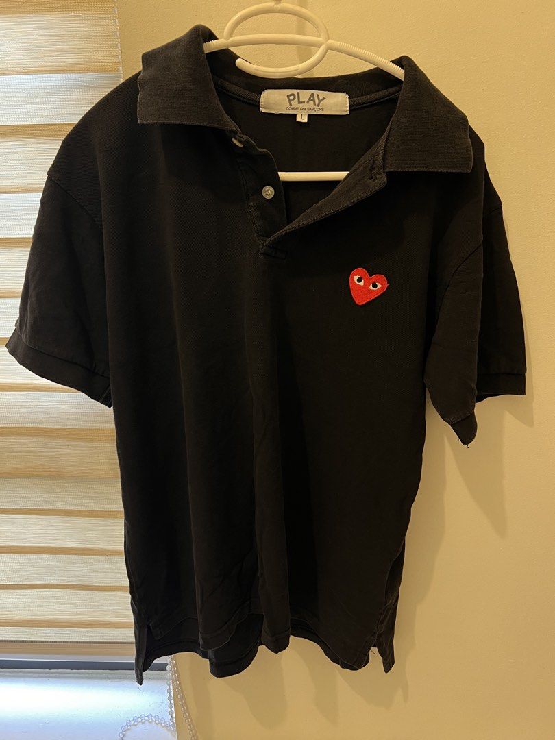 Authentic Comme des Garcons Polo Shirt (Category: Tshirts & Polo Shirts ) located in Las Pinas. Submitted by basicapparel_mnl (Listing ID 1463814604, Image 1). Description: - Brand: PLAY COMME des GARÇONS - check tags for authenticity - Color: Black - Size: L - Feature: Iconic red heart logo on chest - Style: Classic polo collar and button placket - Occasion: Casual wear, layering - Condition: Please check photos for details.