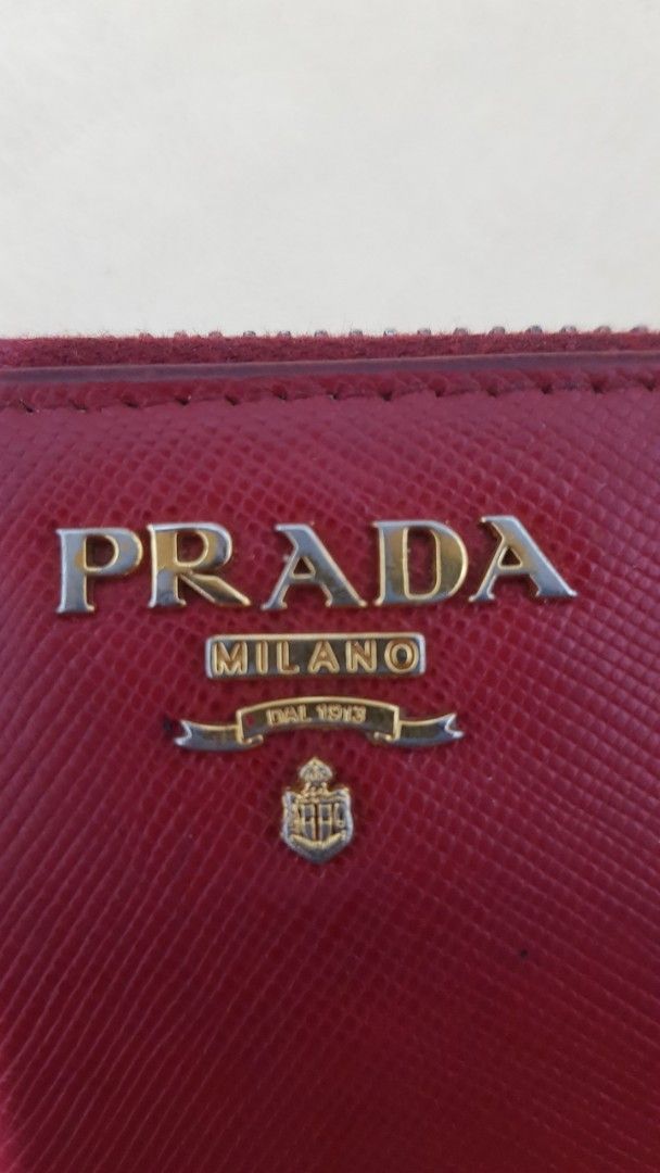 Prada Saffiano Leather Zip Around Wallet Red (Category: Wallets & Card holders) located in Manila. Submitted by nice430 (Listing ID 1463785295, Image 2). Description: - Authentic Prada wallet in red Saffiano leather. - Zip around closure for security. - Multiple interior card slots and compartments. - Shows some signs of wear on interior lining and zipper edges. - Fully functional and stylish. - Comes with original dust bag..