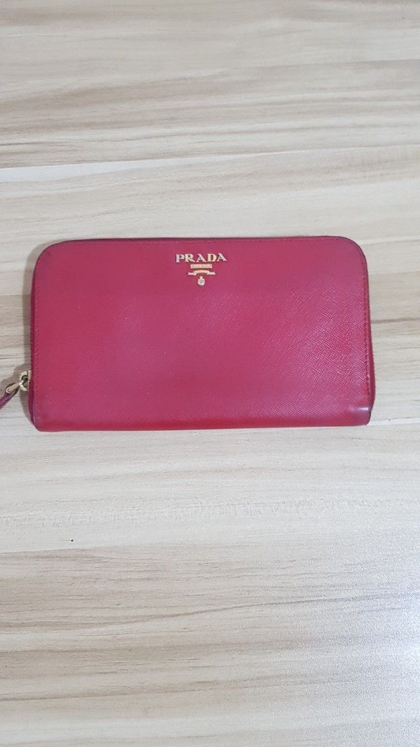 Prada Saffiano Leather Zip Around Wallet Red (Category: Wallets & Card holders) located in Manila. Submitted by nice430 (Listing ID 1463785295, Image 1). Description: - Authentic Prada wallet in red Saffiano leather. - Zip around closure for security. - Multiple interior card slots and compartments. - Shows some signs of wear on interior lining and zipper edges. - Fully functional and stylish. - Comes with original dust bag..