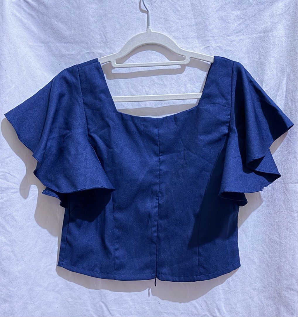 Pretty in Pink Navy Blue Square Neck Flutter Sleeve Top (Category: Sleeveless) located in Paranaque City. Submitted by declutternsell.729 (Listing ID 1463776209, Image 3). Description: - Navy blue top from Pretty in Pink - Features a square neckline - Cute flutter sleeves - Zipper closure at the back - Pairs well with skirts or high-waisted pants - Suitable for dressing up or down.