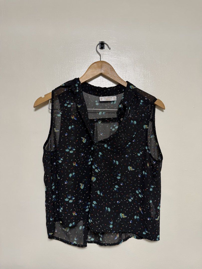 Pull & Bear Black Floral Sleeveless Blouse (Category: Sleeveless) located in Manila. Submitted by don_p (Listing ID 1463868848, Image 1). Description: XS to S - Brand: Pull & Bear - Type: Sleeveless Blouse - Color: Black - Print: Small, colorful abstract all over - Neckline: V-neck with collar and button closure - Material: Sheer - Styling: Great for layering or wearing solo.