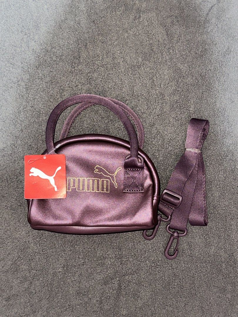 Puma Mini Duffle Bag with Strap (Category: Cross-body Bags) located in Tarlac. Submitted by luan_qw (Listing ID 1463895218, Image 1). Description: - Adorable mini duffle bag from Puma - Eye-catching metallic purple color - Features both handles and a detachable strap - Comes with original tag attached - Ideal for carrying essentials or as a stylish accessory.