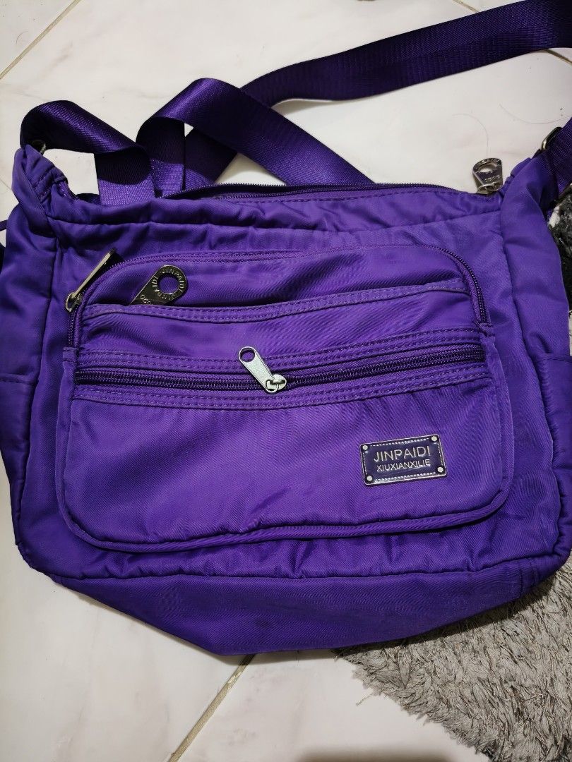 Purple Crossbody Bag (Category: Cross-body Bags) located in Marikina City. Submitted by cloudycookie22 (Listing ID 1463935061, Image 1). Description: Purple crossbody bag. Nylon material. Multiple front zip pockets, adjustable strap. Spacious interior, perfect for daily use. The other is a freebie. .