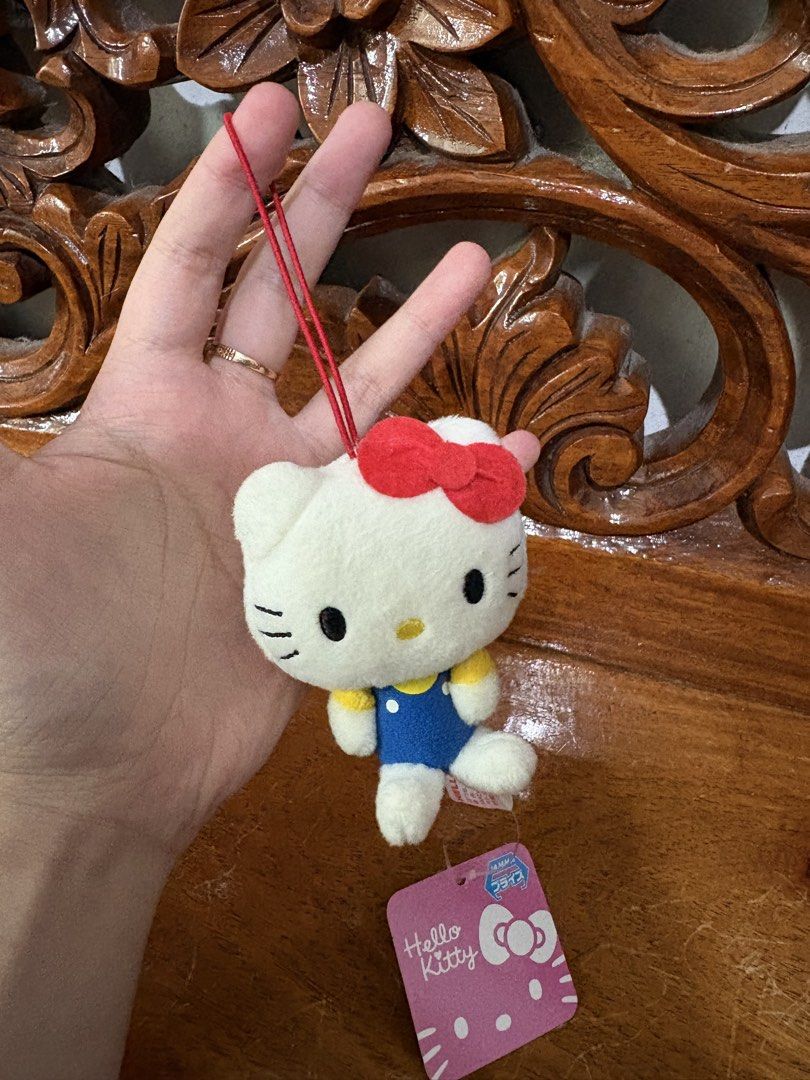 Sanrio Hello Kitty Plush Keychain Toy (Category: Plushies & Soft Toys) located in Quezon City. Submitted by rxyel (Listing ID 1463804925, Image 2). Description: - Adorable Kitty plush toy - Features a classic red bow and blue overalls - Includes a red string for easy hanging - Still has original tags attached - Small and portable size - Ideal for decorating bags, backpacks, or keys - A must-have for Kitty collectors and fans.