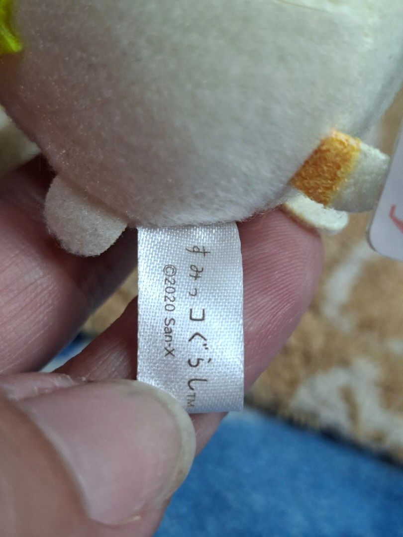 San-X Sumikko Gurashi Plush Keychain (Category: Plushies & Soft Toys) located in Lucena. Submitted by dai_suki (Listing ID 1463856361, Image 3). Description: - Adorable Sumikko Gurashi plush keychain - Features a cute yellow crown detail - Comes with a pink elastic band for easy attachment - Original tag still attached - Authentic San-X product, made in 2020.