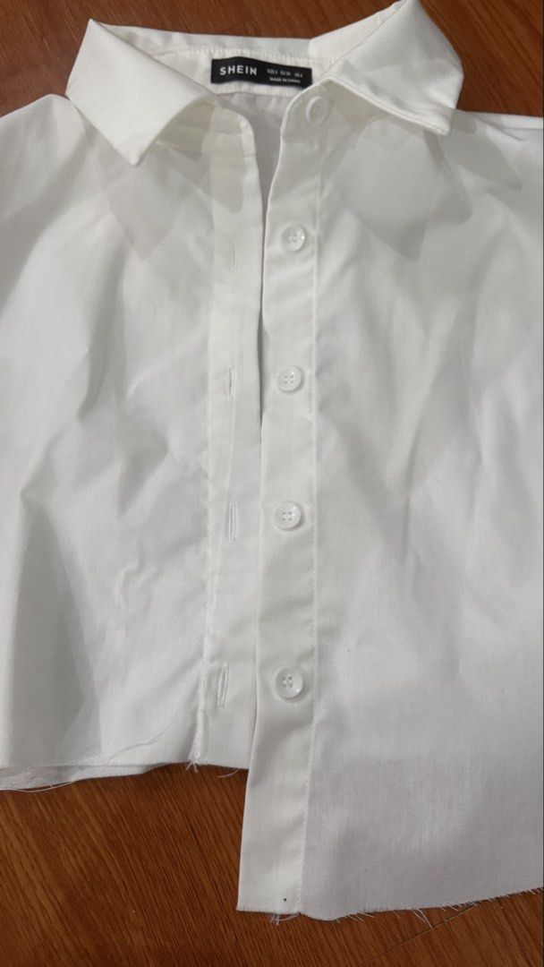 SHEIN White Cropped Button-Up Shirt Size S (Category: Shirts) located in Antipolo. Submitted by japanese.siomai (Listing ID 1463795924, Image 3). Description: - White cropped shirt from SHEIN - Size S - Button-up front with collar - Long sleeves with button cuffs - Raw hem detail - Versatile for layering or wearing solo.