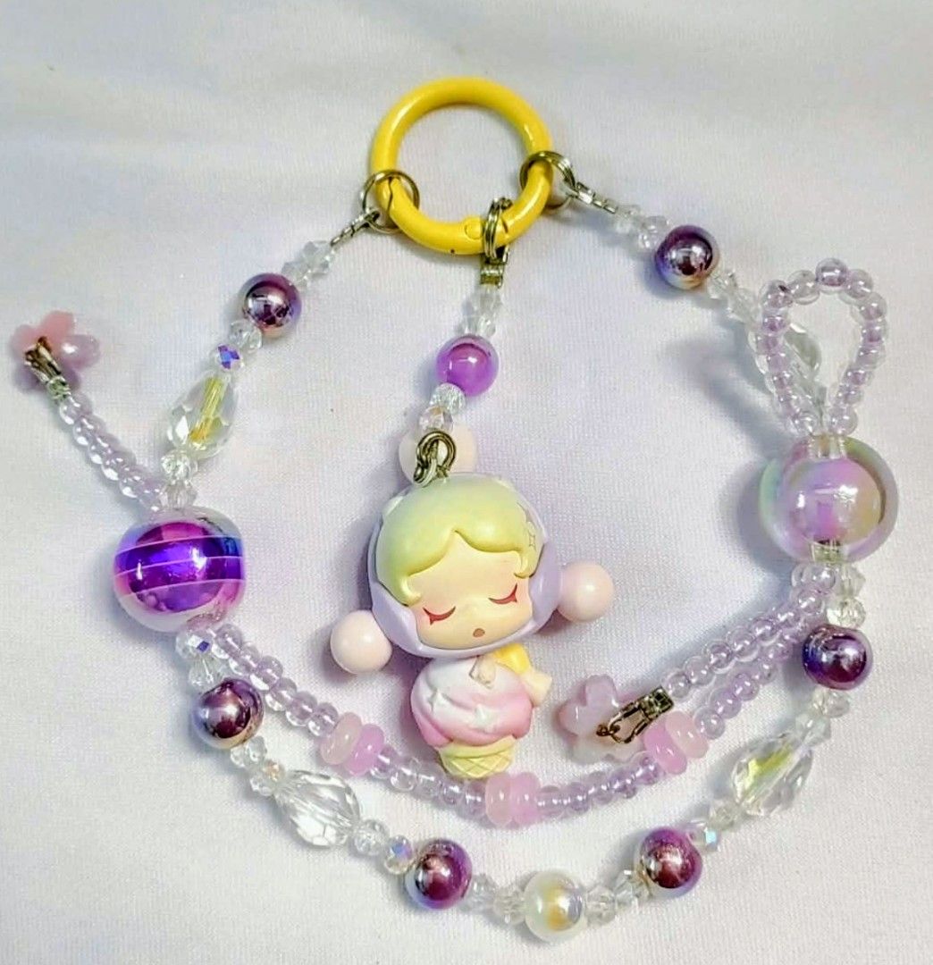 skullpanda popbeans by popmart Diy charms (Category: Charms) located in Caloocan City. Submitted by jark_moonshop (Listing ID 1463860723, Image 1). Description: - Adorable ice cream girl charm keychain - Decorated with purple, clear, and iridescent beads - Includes a yellow ring and a small clasp - Perfect accessory for bags or keys - Unique handmade item.