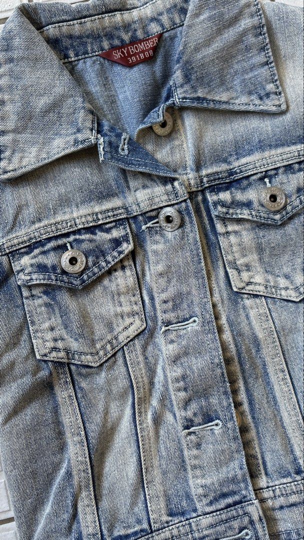 Sky Bomb Denim Shirt (Category: Coats, Jackets and Outerwear) located in Manila. Submitted by bubbles.dan (Listing ID 1463770603, Image 3). Description: - Classic blue denim shirt (short sleeve) - Washed-out look with distressed details - Button-up front - Chest pockets - Ideal for layering - Versatile wardrobe staple.