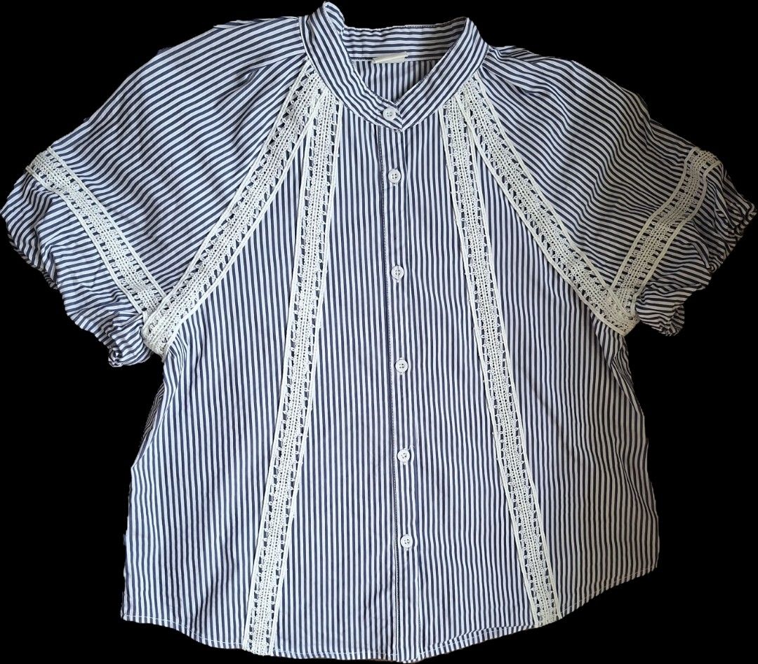 Striped Lace Detail Blouse (Category: Blouses) located in Las Pinas. Submitted by melsv (Listing ID 1463792107, Image 1). Description: - Blue and white striped short-sleeve blouse - Delicate white lace trim on front and sleeves - Mandarin collar with button-up front - Versatile: pairs well with jeans or white pants - Comfortable and stylish for everyday wear.