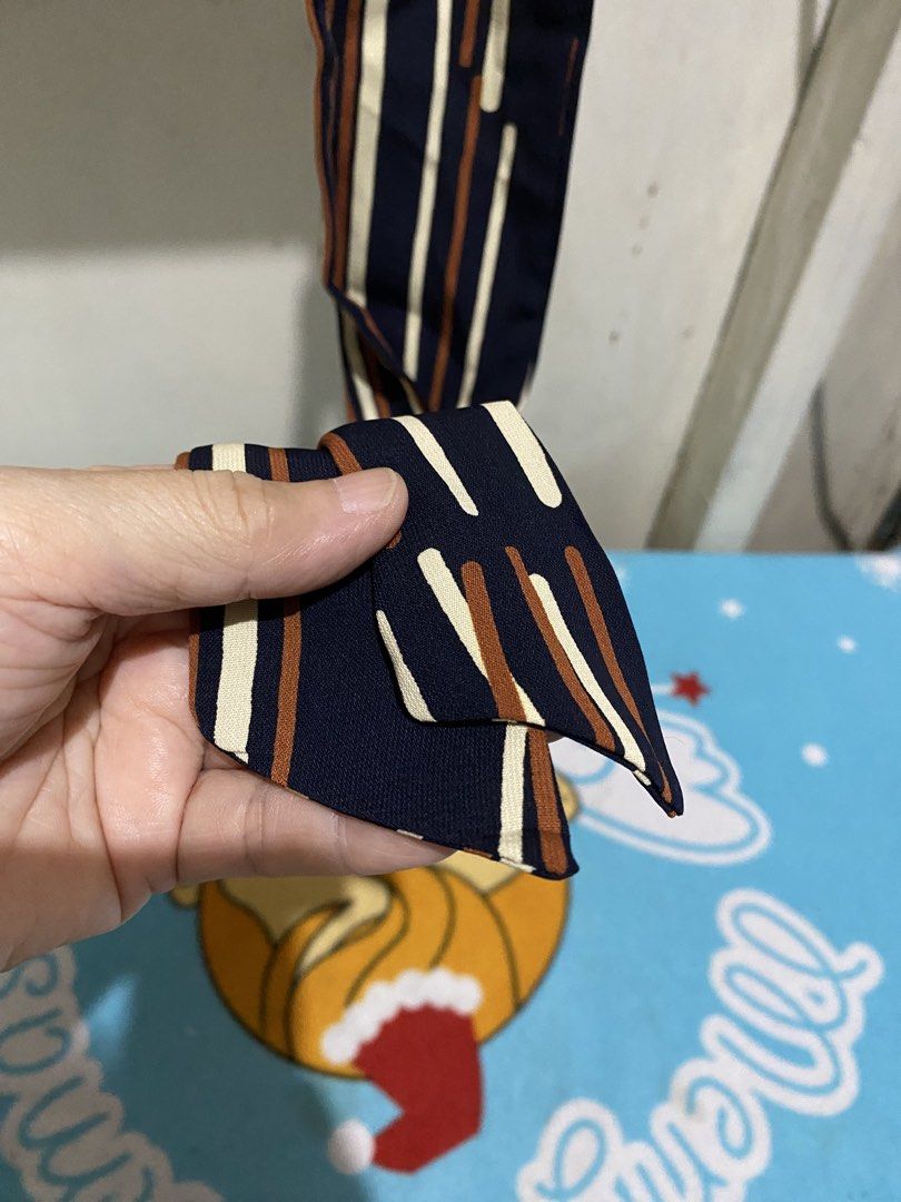 Striped Twilly Scarf with Gold Ring Accent (Category: Scarves) located in Manila. Submitted by resi.diaz (Listing ID 1463840551, Image 3). Description: - Navy blue scarf - Vertical stripes in white and brown - Includes a gold-tone ring for tying - Smooth, comfortable fabric - Versatile accessory for various styling options - Perfect for completing any outfit.