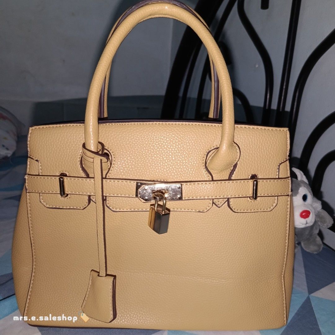 Structured Top-Handle Leather Tote Bag with Lock Detail (Category: Shoulder Bags) located in Cavite. Submitted by mrsesaleshop (Listing ID 1463780391, Image 2). Description: COLOR: – Mustard/Honey Yellow Material: Grained Leather Hardware: Polished Gold-Tone Interior: Spacious main compartment with inner pockets to organize your essentials. Condition: Preloved in excellent condition. Leather has maintained its beautiful shape well. Minor, gentle 