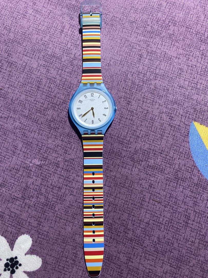 Swatch skin Watch Blue Case Striped Strap (Category: Women's Watches) located in Quezon City. Submitted by maxenelove (Listing ID 1463831435, Image 1). Description: - Brand: Swatch - Case Color: Light Blue - Strap: Colorful striped pattern - Display: Analog (hour, minute, second hands) - Closure: Adjustable buckle - Style: Fun, vibrant, great for everyday wear.