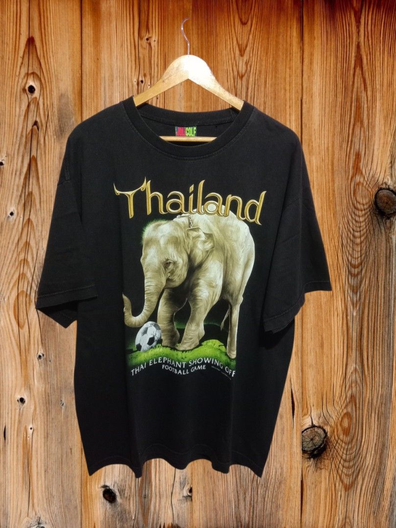 Thailand Bootleg Elephant (Category: Tshirts & Polo Shirts ) located in Davao. Submitted by ayeeasyshop13 (Listing ID 1463895143, Image 1). Description: That's a vintage black Joligolf souvenir t-shirt from Thailand featuring a large graphic of an elephant standing over a soccer ball. Very good condition Issue minimal hairline Size XL on tag Dimension 24/30 350 + SF.