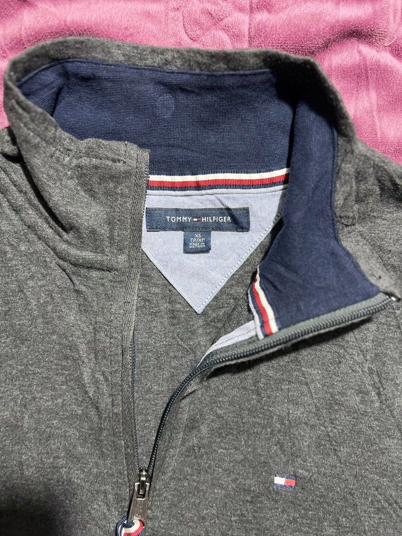 Tommy Hilfiger Grey Quarter Zip Sweatshirt (Category: Coats, Jackets and Outerwear) located in Tagoloan. Submitted by rainebutro69475 (Listing ID 1463913986, Image 3). Description: - Grey Tommy Hilfiger sweatshirt - Quarter zip with navy collar - Small Tommy Hilfiger flag logo on chest - Made in Vietnam - Material: 69% Cotton, 29% Viscose - Size: XS.