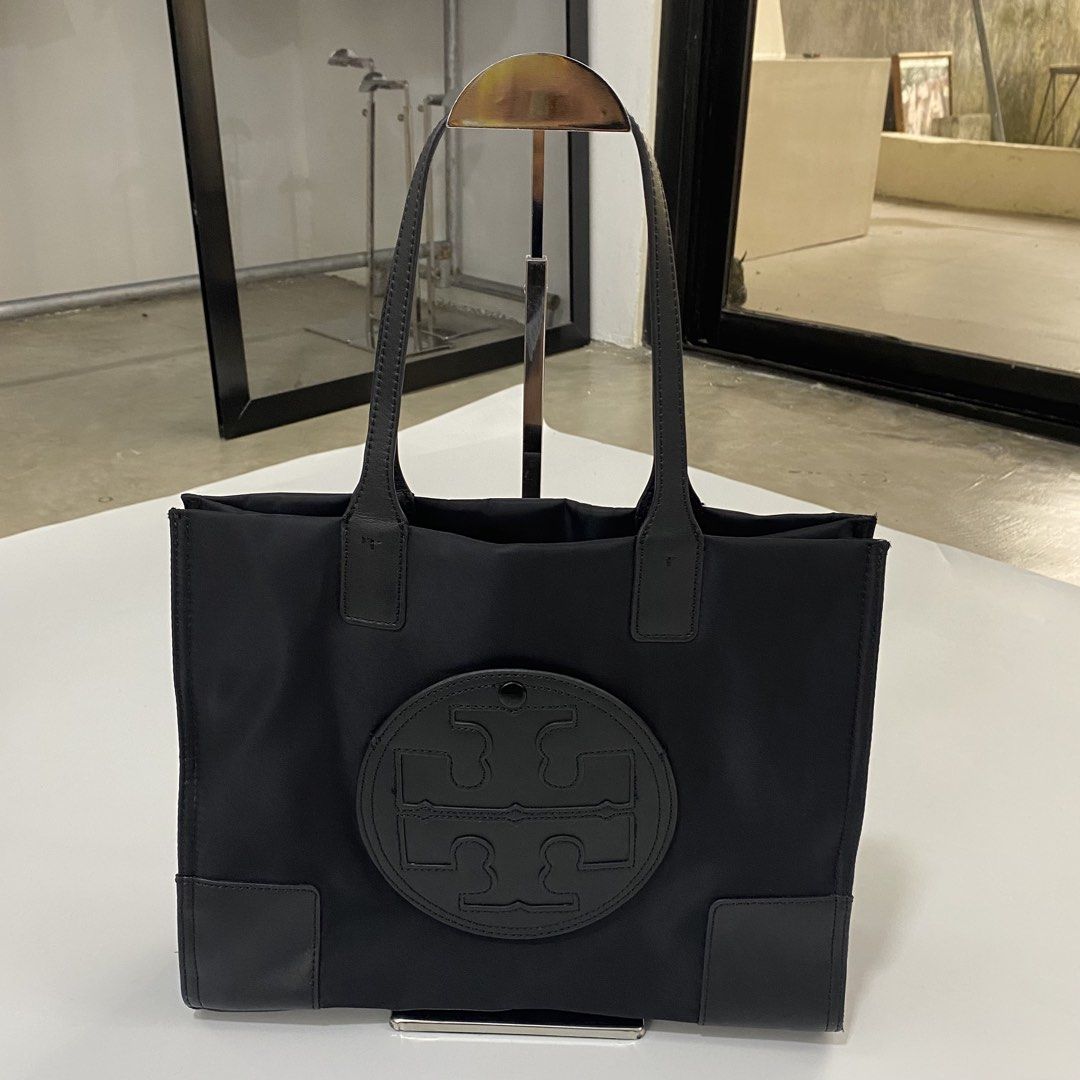 Tory Burch Black Nylon Tote Bag (Category: Tote Bags) located in Manila. Submitted by eddjohn (Listing ID 1463891329, Image 1). Description: - Classic black Tory Burch tote bag - Durable nylon with leather trim - Iconic Double T logo on the front - Spacious interior for essentials - Secure snap closure on top - Interior zip pocket for valuables - Ideal for daily use or travel.