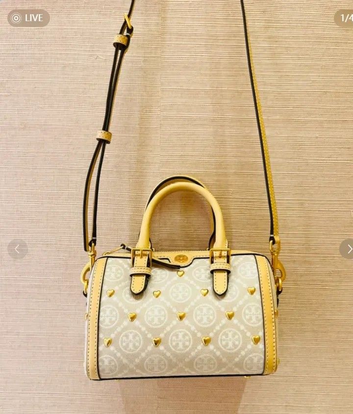 Tory Burch Monogram Lasercut Bucketbag (Category: Shoulder Bags) located in Quezon City. Submitted by Diaholics_Jewelry (Listing ID 1463889344, Image 2). Description: - Cute Tory Burch barrel bag - Beige and cream monogram print - Gold heart details - Tan leather trim and handles - Detachable crossbody strap included - Small protective feet on the bottom - Ideal for everyday use or a night out.