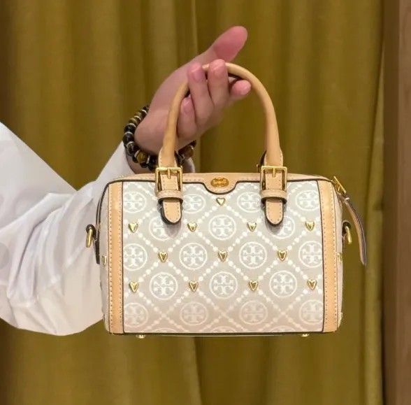 Tory Burch Monogram Lasercut Bucketbag (Category: Shoulder Bags) located in Quezon City. Submitted by Diaholics_Jewelry (Listing ID 1463889344, Image 1). Description: - Cute Tory Burch barrel bag - Beige and cream monogram print - Gold heart details - Tan leather trim and handles - Detachable crossbody strap included - Small protective feet on the bottom - Ideal for everyday use or a night out.