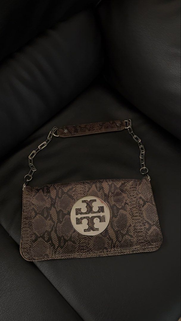 Tory Burch Reva Python Clutch (Category: Luxury Bags & Wallets) located in Davao. Submitted by _iconculture (Listing ID 1463761838, Image 2). Description: AVAILABLE Tory Burch Reva Python Clutch — ₱3,950 H: 6in W: 11in *Rank A Condition (very good) *Chain strap is detachable! *Hairline scratches only metal only *Comes w Generic dustbag More photos DM 🩵 — Not affiliated with featured brand/s. — 100% Authentic • Money-Back Guarantee — Color may va