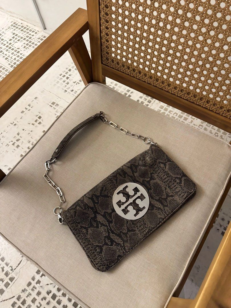 Tory Burch Reva Python Clutch (Category: Luxury Bags & Wallets) located in Davao. Submitted by _iconculture (Listing ID 1463761838, Image 1). Description: AVAILABLE Tory Burch Reva Python Clutch — ₱3,950 H: 6in W: 11in *Rank A Condition (very good) *Chain strap is detachable! *Hairline scratches only metal only *Comes w Generic dustbag More photos DM 🩵 — Not affiliated with featured brand/s. — 100% Authentic • Money-Back Guarantee — Color may va