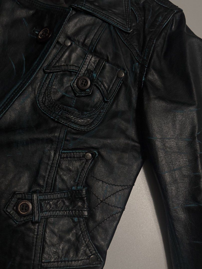 TOUGH Jeansmith Black Leather Jacket (Category: Coats, Jackets and Outerwear) located in Alaminos. Submitted by outfitcheck.ph (Listing ID 1463869566, Image 3). Description: - Brand: TOUGH Jeansmith - Material: Black Leather - Style: Cropped jacket - Features: Unique pocket details, button closures, waist tie - Accents: Distressed blue details - Perfect for: Creating a statement look.