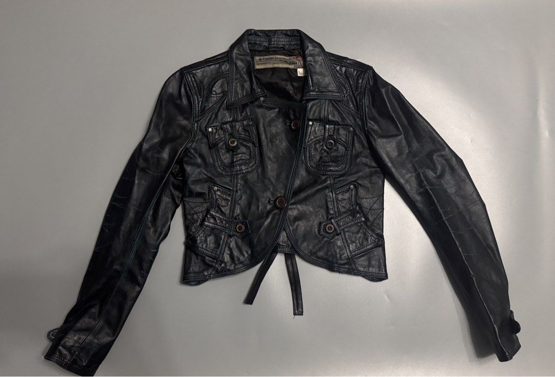 TOUGH Jeansmith Black Leather Jacket (Category: Coats, Jackets and Outerwear) located in Alaminos. Submitted by outfitcheck.ph (Listing ID 1463869566, Image 1). Description: - Brand: TOUGH Jeansmith - Material: Black Leather - Style: Cropped jacket - Features: Unique pocket details, button closures, waist tie - Accents: Distressed blue details - Perfect for: Creating a statement look.