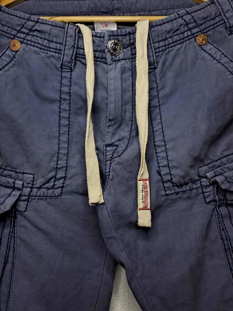 🔥True Religion Multi-Pocket Utility Cargo Pants🔥 (Category: Trousers) located in Quezon City. Submitted by yaseen73 (Listing ID 1463807793, Image 2). Description: True Religion Multi - Pocket Utility Cargo Pants Blue With A Drawstring Waist True Religion Logo and Adjustable Leg Opening Wearing Size : 30 on Tag Actual Waistline : 33/34 Front Rise 11 Front Thigh 12 Leg Opening 9 Length 43 - Needs Wash - Color Rate : 9.2/10 - With Minimal Sun Fade