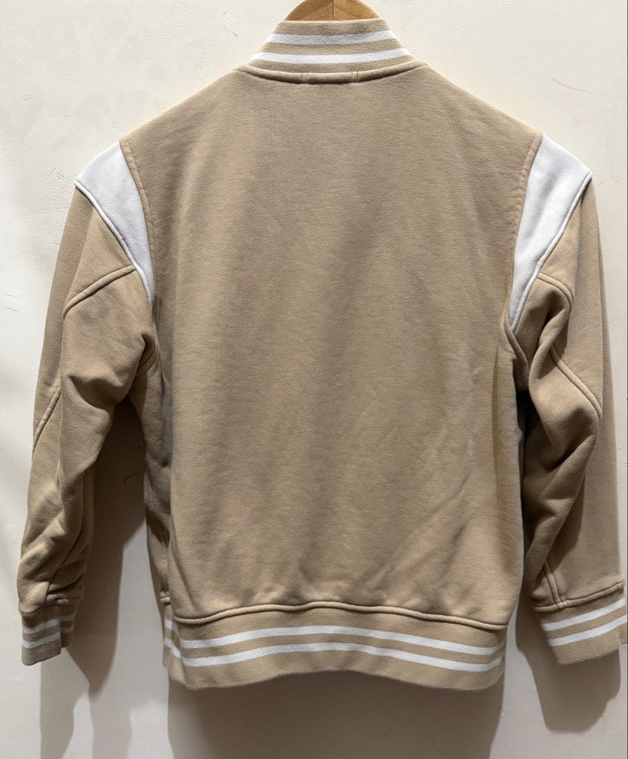 Uniqlo Kids Varsity Jacket Size 140 (Category: Babies & Kids Fashion) located in Las Pinas. Submitted by mjm21 (Listing ID 1463851978, Image 2). Description: - Uniqlo kids varsity jacket - Tan color with white sleeves - Striped cuffs and hem - Chest patch detail - Snap button closure - Ideal for everyday wear.