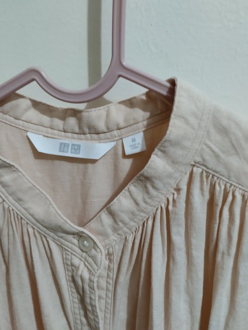 Uniqlo Sleeveless Button-Up Top M Peach (Category: Sleeveless) located in Mabalacat. Submitted by uniqlover (Listing ID 1463871109, Image 3). Description: - Uniqlo sleeveless top - Lovely peach color - Band collar with button-up front - Gathered detail at the yoke - Versatile for casual wear or layering - Material: 55% linen, 45% rayon - Size: Medium (M).