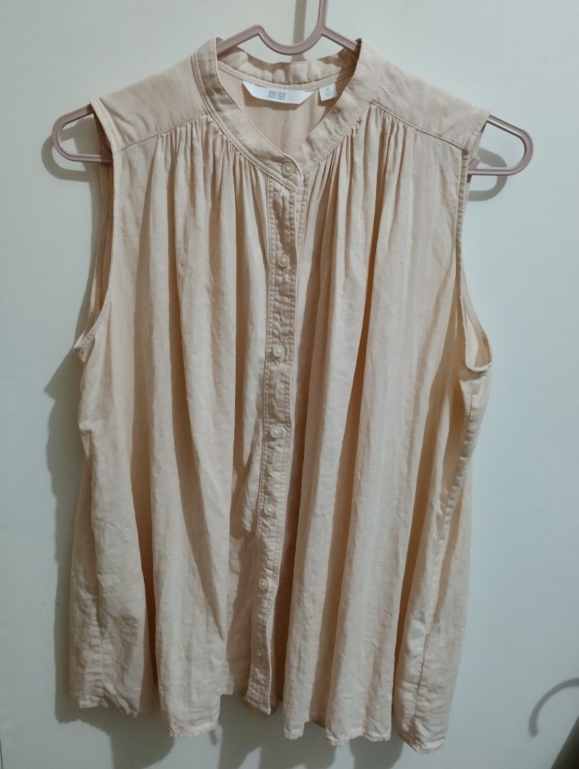 Uniqlo Sleeveless Button-Up Top M Peach (Category: Sleeveless) located in Mabalacat. Submitted by uniqlover (Listing ID 1463871109, Image 2). Description: - Uniqlo sleeveless top - Lovely peach color - Band collar with button-up front - Gathered detail at the yoke - Versatile for casual wear or layering - Material: 55% linen, 45% rayon - Size: Medium (M).