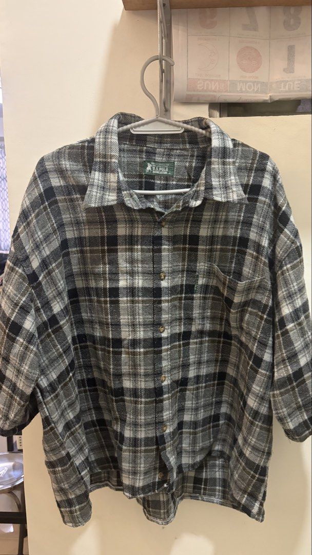U.S. Polo Assn. Plaid Button-Up Shirt (Category: Tshirts & Polo Shirts ) located in Davao. Submitted by davaodeclutters (Listing ID 1463765476, Image 1). Description: - Brand: U.S. Polo Assn. - Color: Grey and black plaid - Style: Short sleeve, button-up shirt - Features: Chest pocket - Material: Soft fabric - cropped, 26x26.