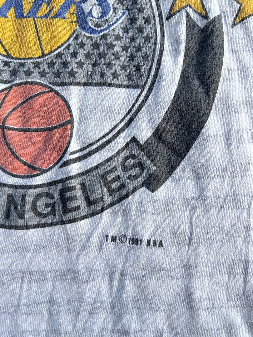 Vintage 90’s Lakers Logo 7 Tag (Category: Tshirts & Polo Shirts ) located in Baao. Submitted by prettysixtythrift_17 (Listing ID 1463753873, Image 3). Description: ▪️Size: M on tag ▪️Length: 28.5 ▪️Width: 19.5 ▪️Color Rate: 10/10 ▪️Condition: Excellent ▪️Issue: None.