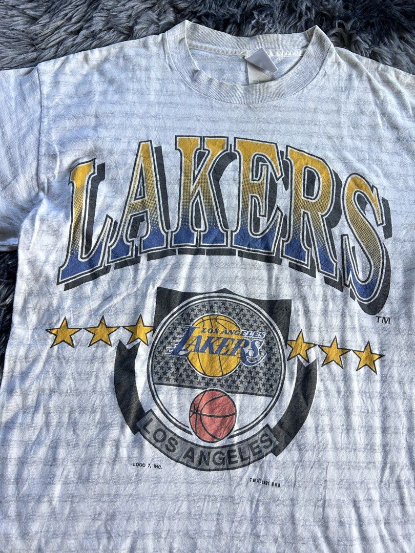 Vintage 90’s Lakers Logo 7 Tag (Category: Tshirts & Polo Shirts ) located in Baao. Submitted by prettysixtythrift_17 (Listing ID 1463753873, Image 2). Description: ▪️Size: M on tag ▪️Length: 28.5 ▪️Width: 19.5 ▪️Color Rate: 10/10 ▪️Condition: Excellent ▪️Issue: None.