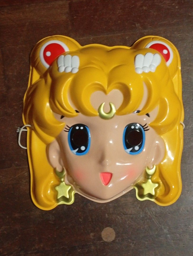 Vintage Sailor Moon Plastic Mask Toy (Category: Vintage Collectibles) located in San Mateo. Submitted by waynetek14 (Listing ID 1463833502, Image 2). Description: Selling a vintage Sailor Moon mask. Made of plastic. Features the character's iconic blonde hair, blue eyes, and star earrings. Has eye holes for wearing. Great for collectors or cosplay. Shows some signs of age but still displays well. A fun piece of anime memorabilia..