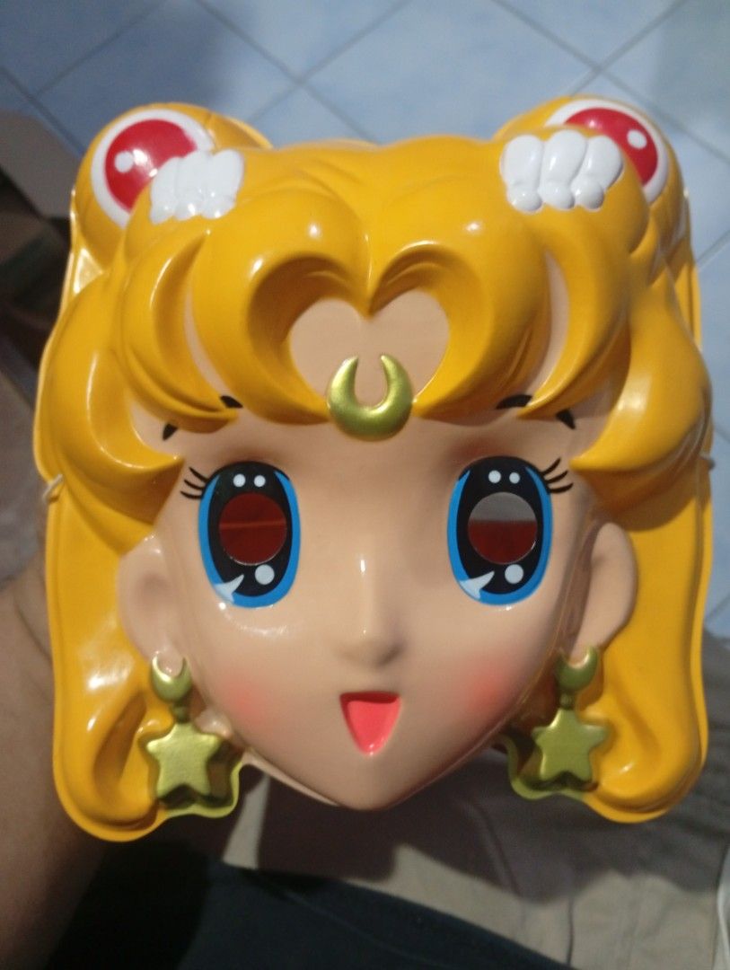 Vintage Sailor Moon Plastic Mask Toy (Category: Vintage Collectibles) located in San Mateo. Submitted by waynetek14 (Listing ID 1463833502, Image 1). Description: Selling a vintage Sailor Moon mask. Made of plastic. Features the character's iconic blonde hair, blue eyes, and star earrings. Has eye holes for wearing. Great for collectors or cosplay. Shows some signs of age but still displays well. A fun piece of anime memorabilia..