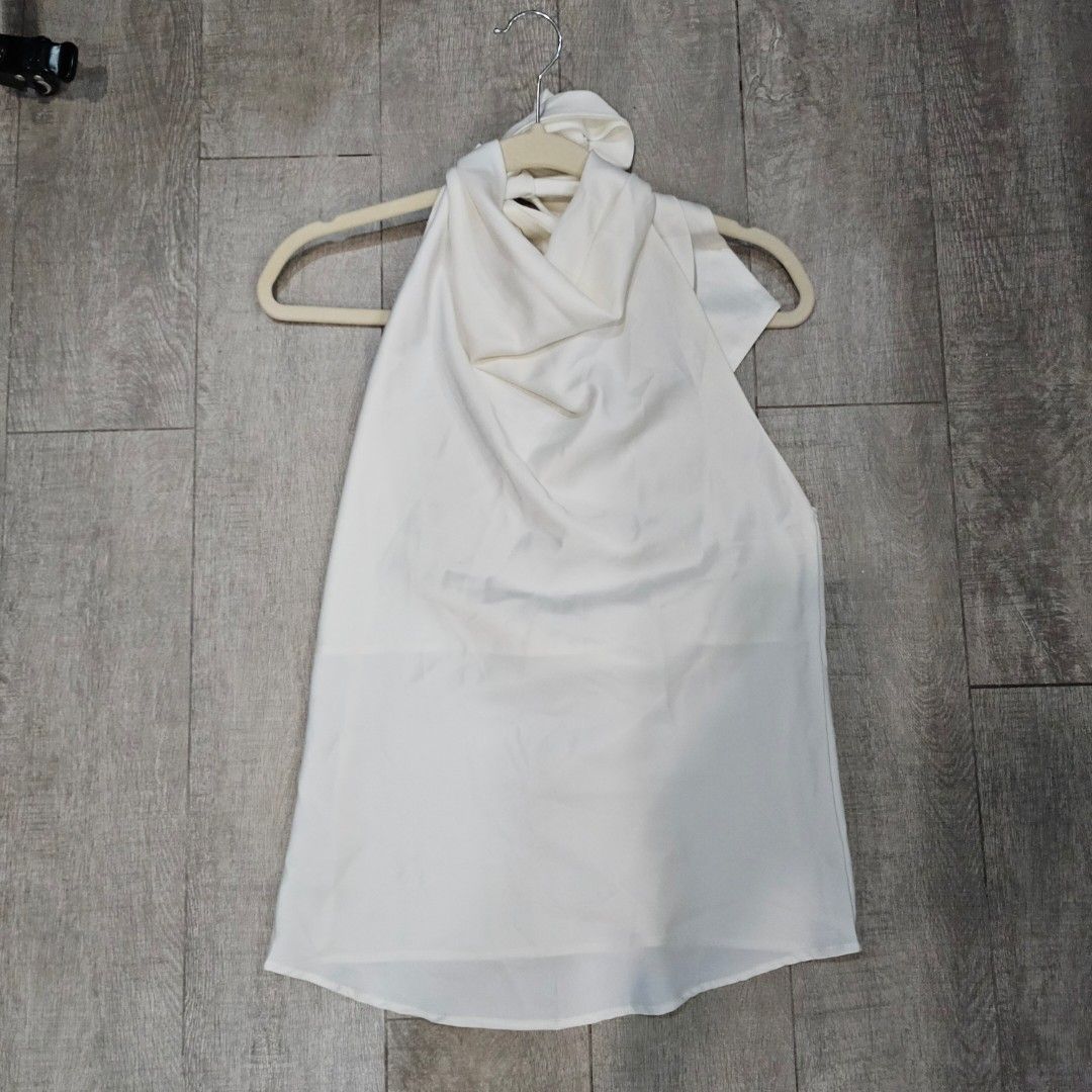 White Halter Neck Low Back Top (Category: Sleeveless) located in Makati City. Submitted by goldenbird.001 (Listing ID 1463887691, Image 1). Description: - White halter neck top - Features a tie detail at the front - Made from a flowy material - Perfect for dressing up or down - Easy to style with various bottoms - Ideal for casual outings or nights out.