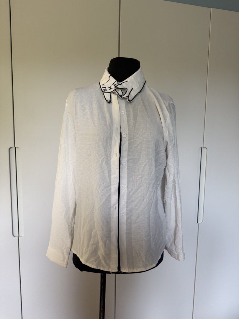 White Long Sleeve Shirt with Cat Collar Detail (Category: Longsleeves) located in Manila. Submitted by cristycrab247 (Listing ID 1463772611, Image 1). Description: - White long sleeve shirt - Unique collar with black embroidered cat design - Button-up front - Lightweight fabric, perfect for layering - Simple and cute style - well loved shirt, please adjust expectations .