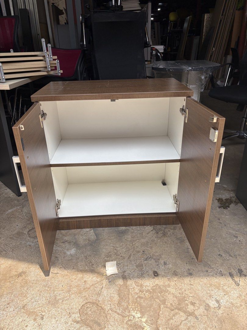 Wooden Two-Door Cabinet with Lock (Category: Shelves, Cabinets & Racks) located in Valenzuela. Submitted by cha_leng.861 (Listing ID 1463823124, Image 2). Description: - Brown wooden cabinet - Two doors with lock and two handles - Two shelves inside for ample storage - Approximate dimensions: 2 feet tall x 2 feet wide - Perfect for home or office organization.