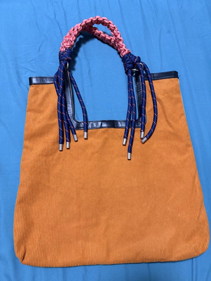 Woven Tote Bag with Rope Handles (Category: Tote Bags) located in Mandaluyong City. Submitted by sarisaringtinda (Listing ID 1463864436, Image 3). Description: - Unique woven tote bag - Braided rope handle in pink and navy blue - Tan herringbone weave body - Bright orange corduroy back - Black trim around top opening - Ideal for everyday use or beach trips.
