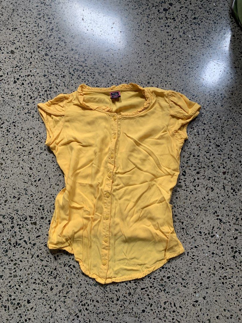 Yellow Button-Up Top with Ruffle Neckline (Category: Blouses) located in Quezon City. Submitted by p.j.c.a.r.o.u.s.e.l.l.i.n.g (Listing ID 1463787492, Image 1). Description: - Cute yellow short-sleeve top - Button-up front - Ruffled neckline - Soft and lightweight fabric - Versatile for casual or dressy occasions - Easy to pair with jeans or skirts.