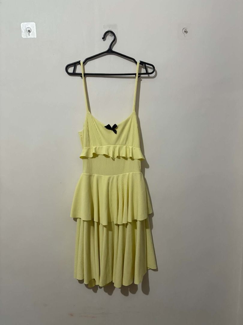 Yellow Ruffled Tiered Mini Dress with Bow (Category: Dresses) located in San Leonardo. Submitted by burgossanleonardo.12345 (Listing ID 1463915830, Image 1). Description: - Adorable yellow mini dress - Features delicate spaghetti straps - Stylish ruffled tier design - Cute small black bow detail at the bust - Comfortable ribbed fabric texture - Ideal for casual days or fun events.