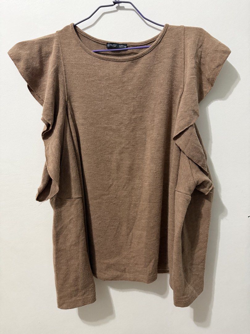 ZARA Brown Cold Shoulder Ruffle Long Sleeve Top (Category: Longsleeves) located in Malolos. Submitted by eadiana (Listing ID 1463758367, Image 3). Description: - Brown long sleeve top - Features cold shoulder cutouts - Ruffled details on sleeves - Ribbed fabric texture - Versatile for pairing with skirts or jeans - Comfortable and stylish for casual outfits.