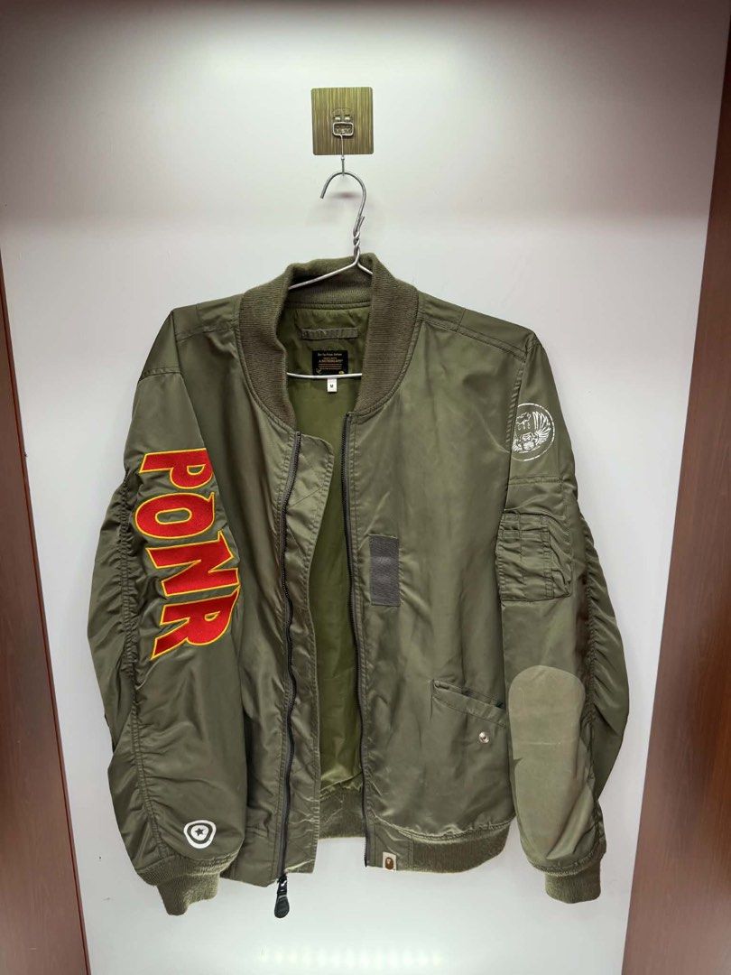 A Bathing Ape BAPE Shark Bomber Jacket Green (Category: Coats, Jackets and Outerwear) located in Alfonso. Submitted by lukemarco17 (Listing ID 1464020586, Image 2). Description: - Classic BAPE Shark Bomber Jacket - Color: Green - Iconic shark graphic on the back - 'PONR' text detail on the sleeve - Zipper closure - Ribbed collar, cuffs, and hem - Size: M - Essential for any streetwear collection.