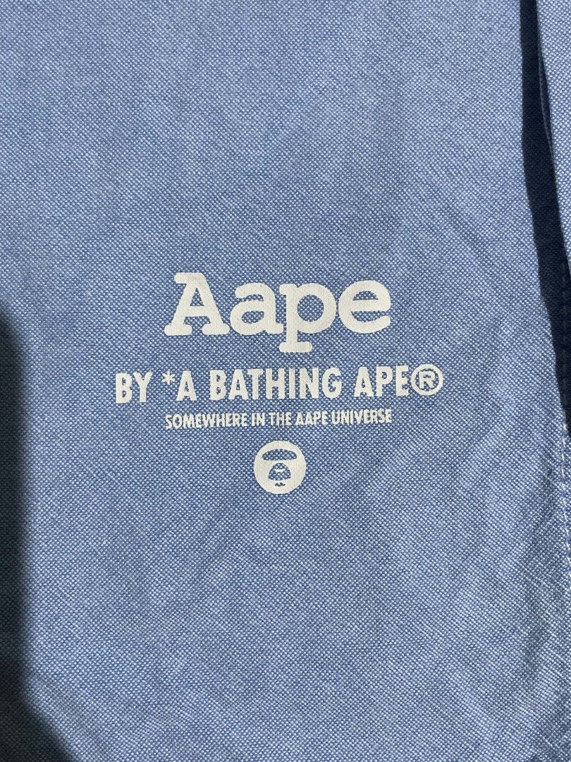 AAPE BY A BATHING APE Oxford Button-Up Shirt (Category: Tshirts & Polo Shirts ) located in Manila. Submitted by mikeee03 (Listing ID 1464117407, Image 3). Description: - Brand: AAPE BY A BATHING APE - Color: Light Blue - Style: Oxford Shirt - Size: S on tag, but fit to medium - Features: Vertical logo print on placket, logo on chest pocket, camouflage print collar lining - Occasion: Casual or smart-casual wear - All details nandyan na.