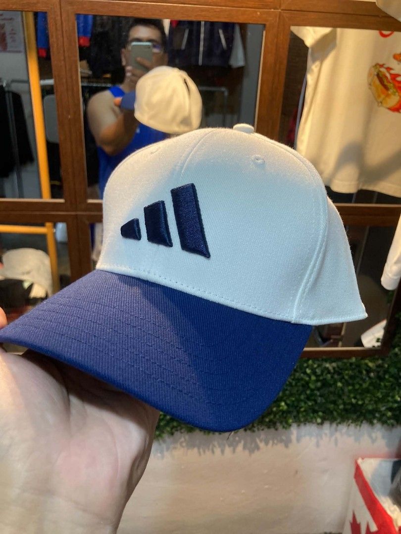 Adidas Baseball Cap - White/Blue - Size M/L (Category: Caps & Hats) located in Trece Martires City. Submitted by djaothriftshop (Listing ID 1463972477, Image 1). Description: - Adidas baseball cap - Color: White crown with navy blue brim and logo - Size: M/L, fits 58cm - Origin: Made in Vietnam - Condition: Original tag attached - Original Price: PHP 1,400.00 - Ideal for: Everyday wear.